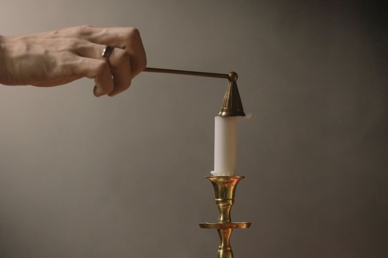 Putting out a candle with a candle snuffer